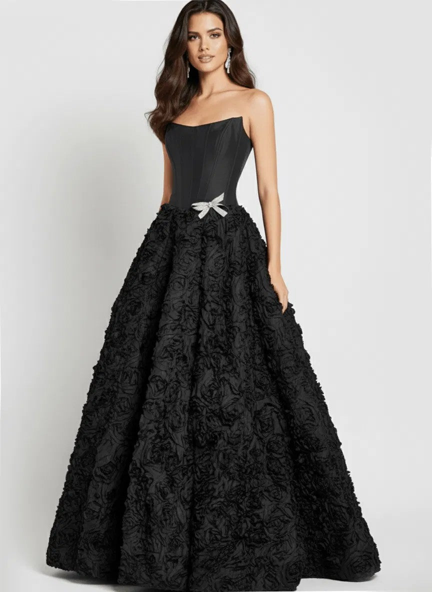 A woman wearing the Jovani 47695 long prom dress, featuring a strapless corset bodice, 3D rosette skirt, and a small silver waist bow, stands against a plain background.